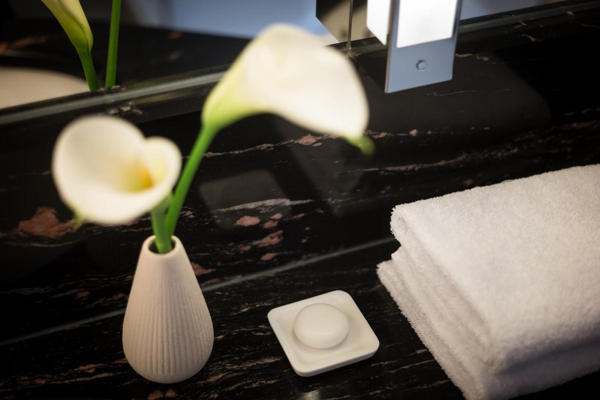 Grand Elysee Hamburg Hamburgo Exterior foto A small vase of flowers in a hotel room